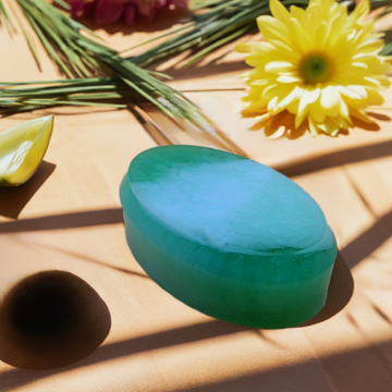 a table topped with a green piece of cake next to a yellow flower