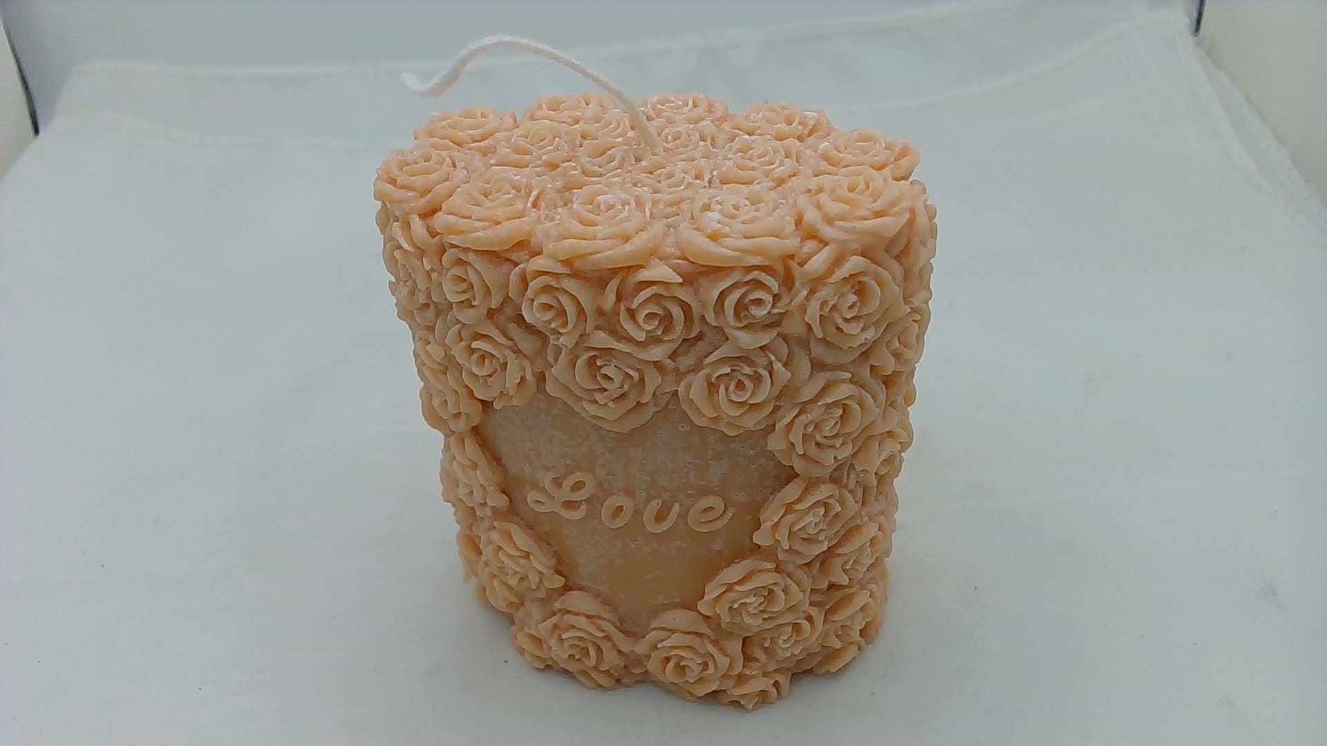 a candle that is shaped like roses on a table