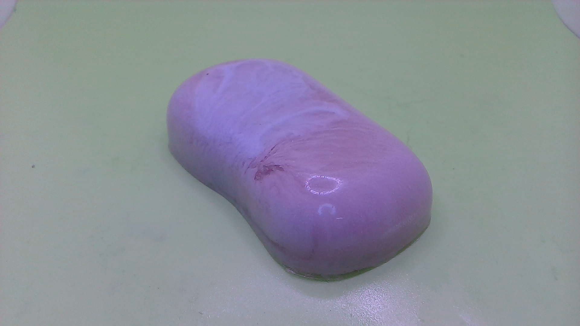 a purple soap is sitting on a white surface