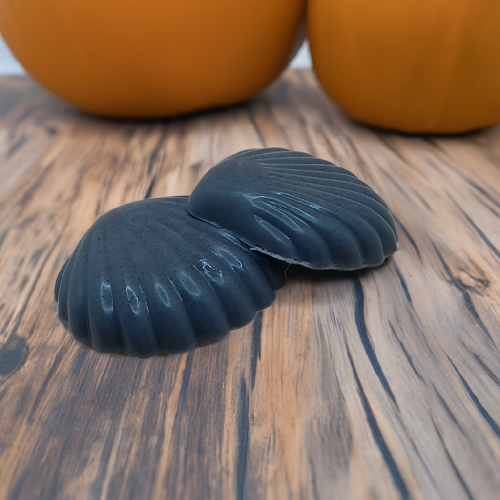 a pair of black seashells sitting on a wooden table