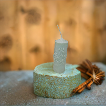 a small candle sitting on top of a stone block