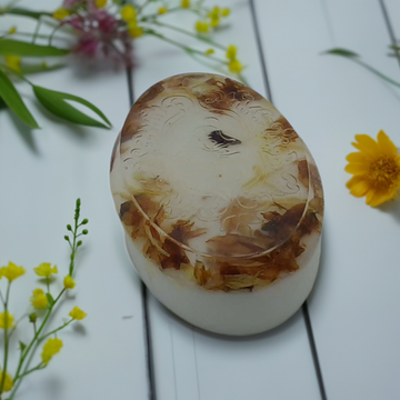 a white box sitting on top of a table next to flowers