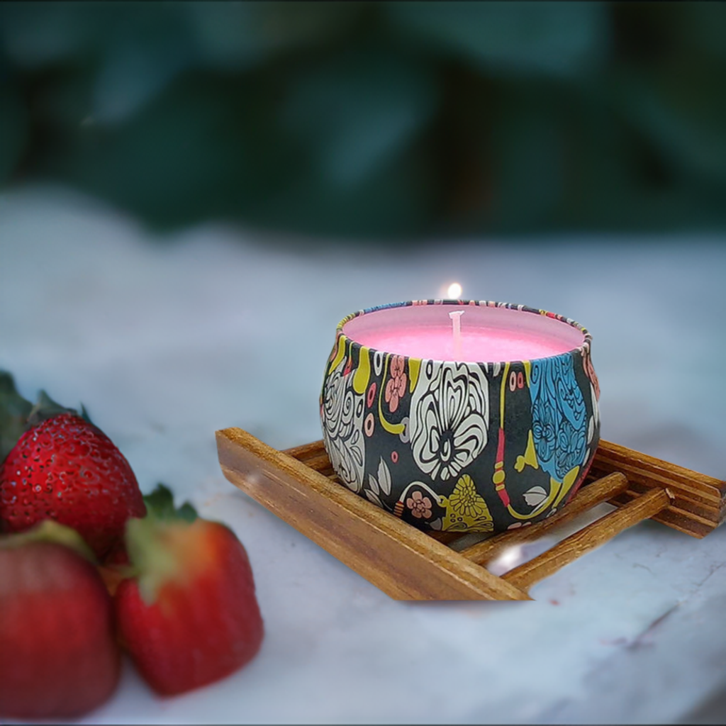 a candle sits on a tray next to strawberries