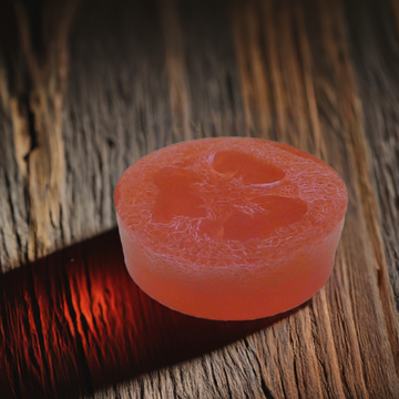 a close up of a red object on a wooden surface