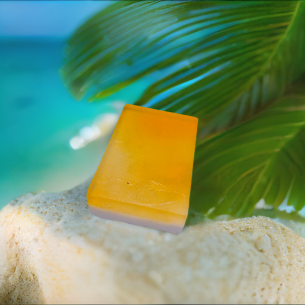 a piece of yellow glass sitting on top of a sandy beach