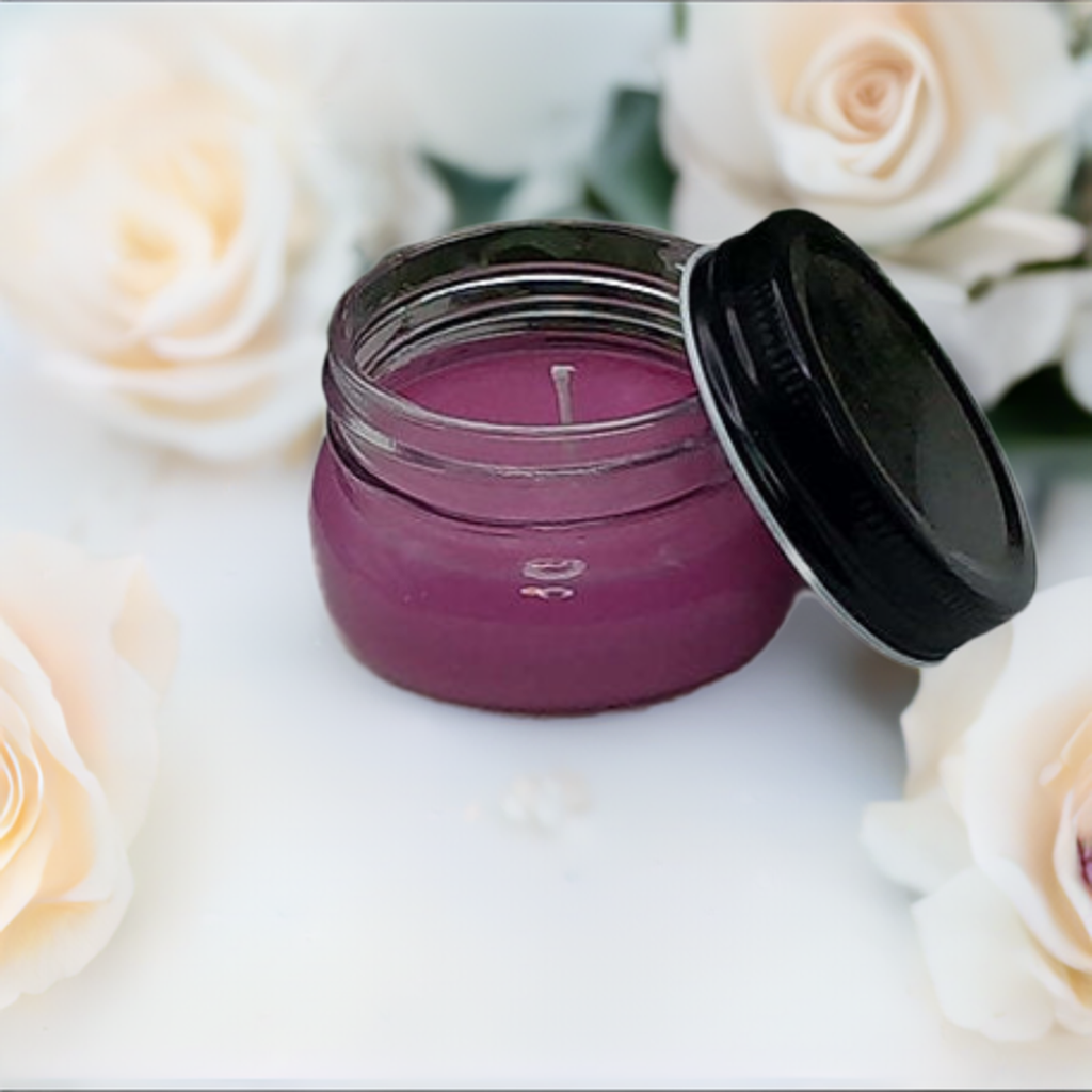 a jar with a candle sitting next to some flowers