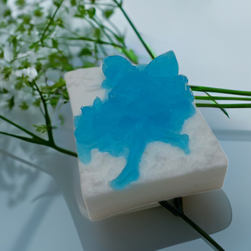 a soap bar sitting on top of a table next to a bouquet of flowers