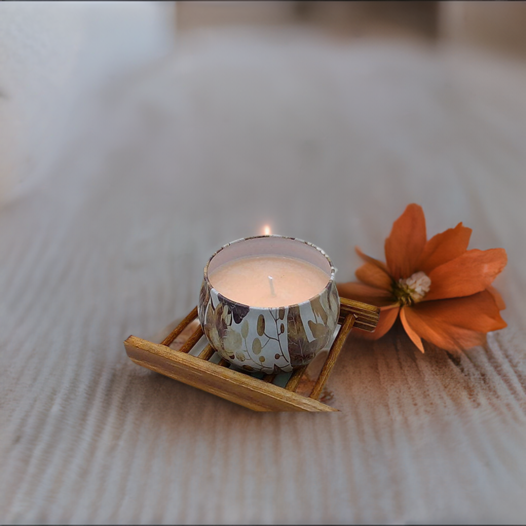 a candle sitting on top of a wooden tray next to a flower