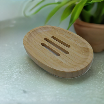 a wooden soap dish sitting next to a potted plant