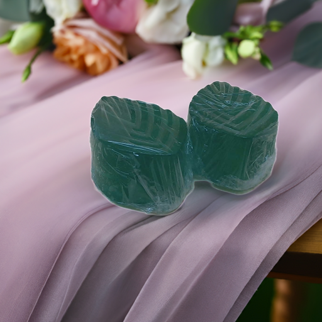 a couple of green candles sitting on top of a table