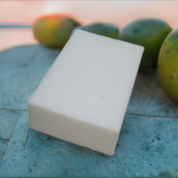 a soap bar sitting on top of a table next to limes