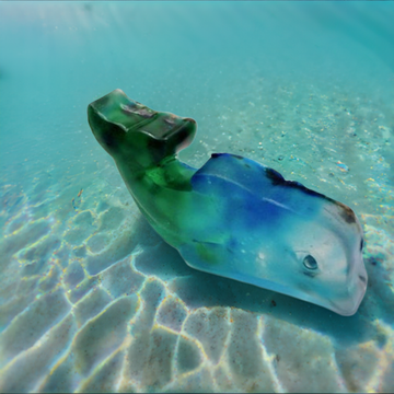 a blue and green plastic fish in the water