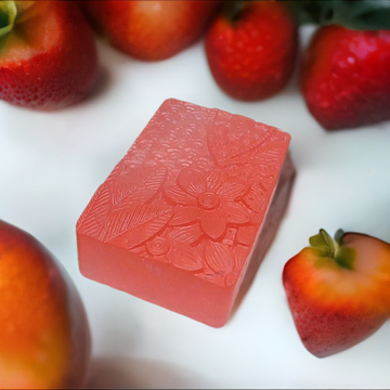 a soap bar sitting on top of a table surrounded by strawberries