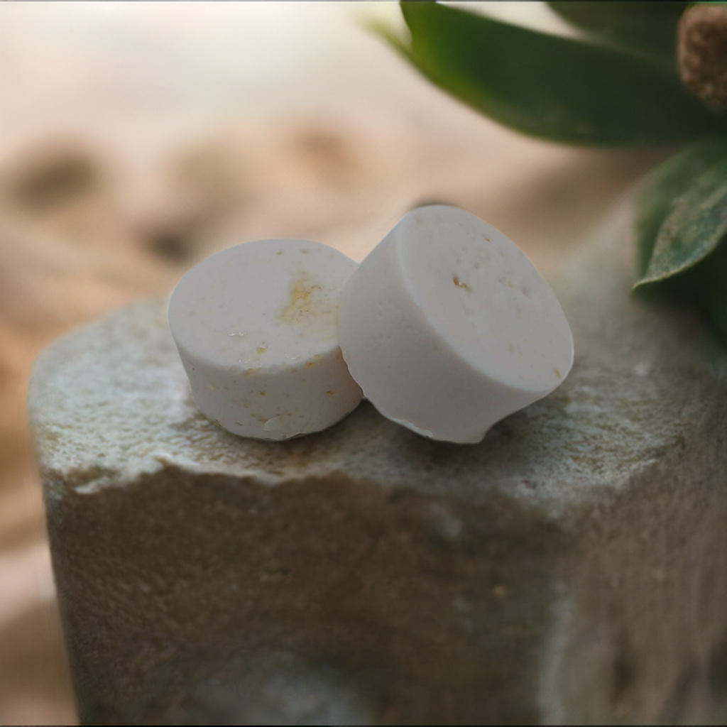 a couple of white pills sitting on top of a rock