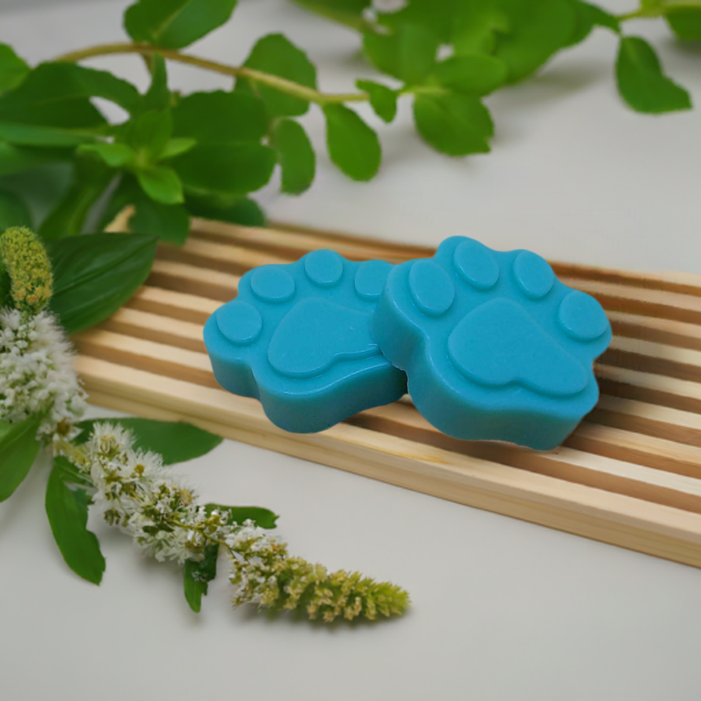 a blue dog paw soap sitting on top of a wooden tray