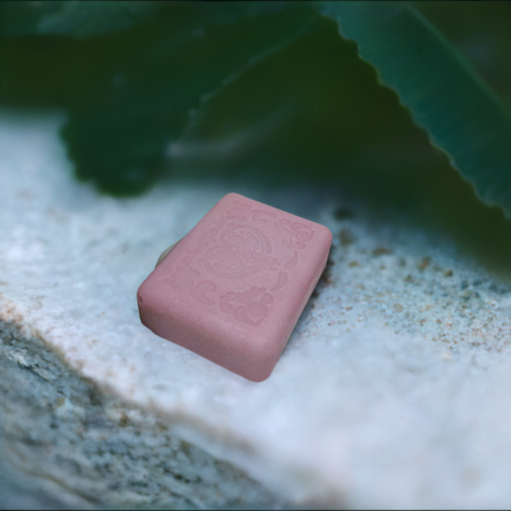 a pink soap sitting on top of a white surface