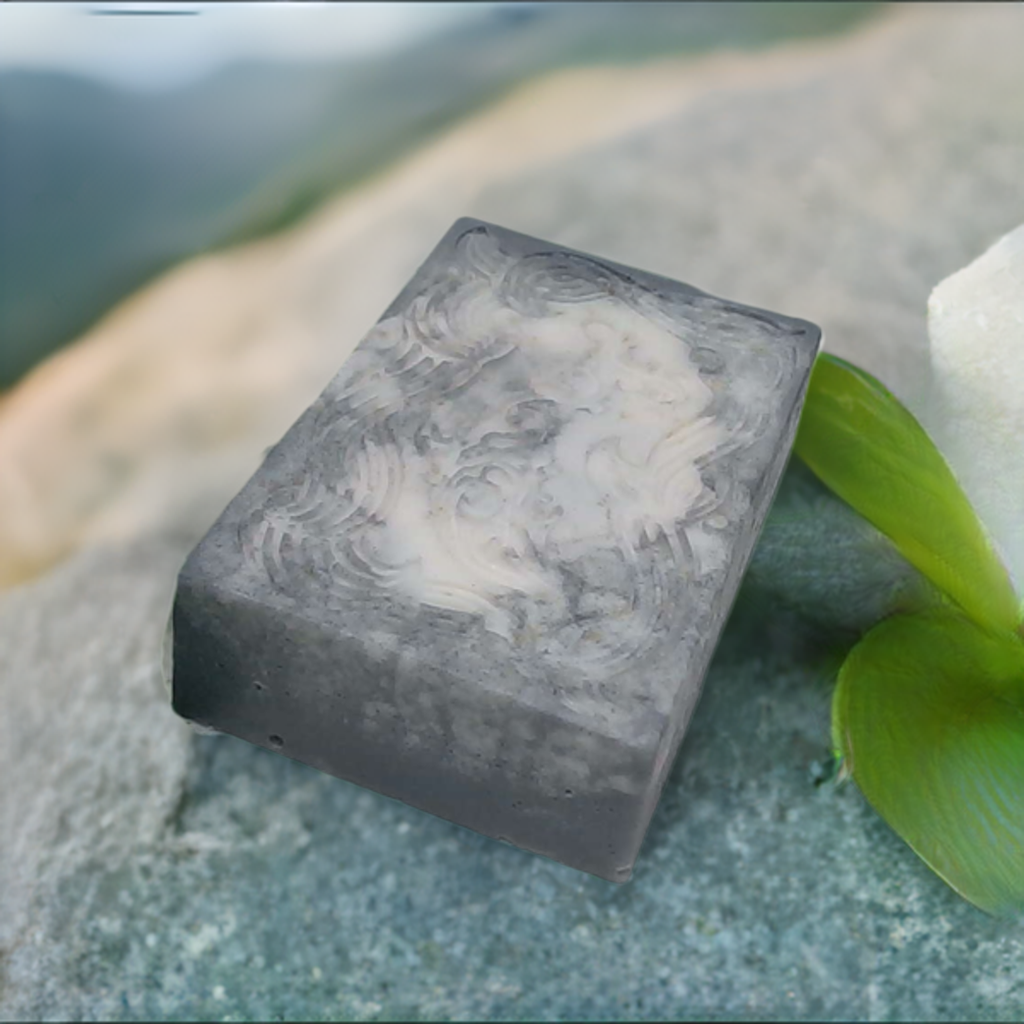 a soap bar sitting on top of a rock next to a flower