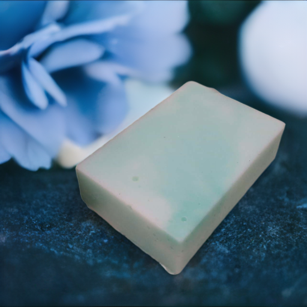 a soap bar sitting next to a blue flower