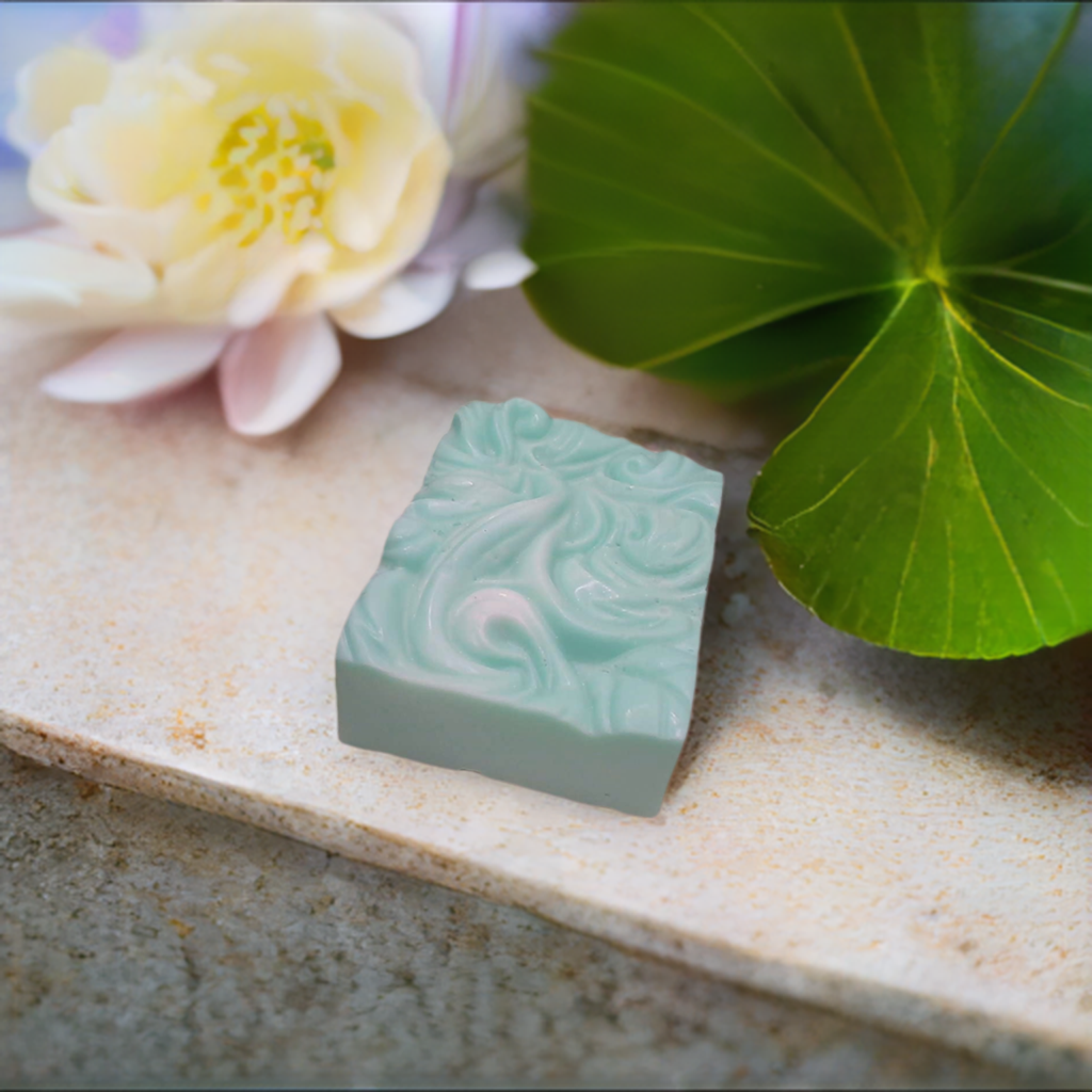 a soap bar sitting on top of a counter next to a flower