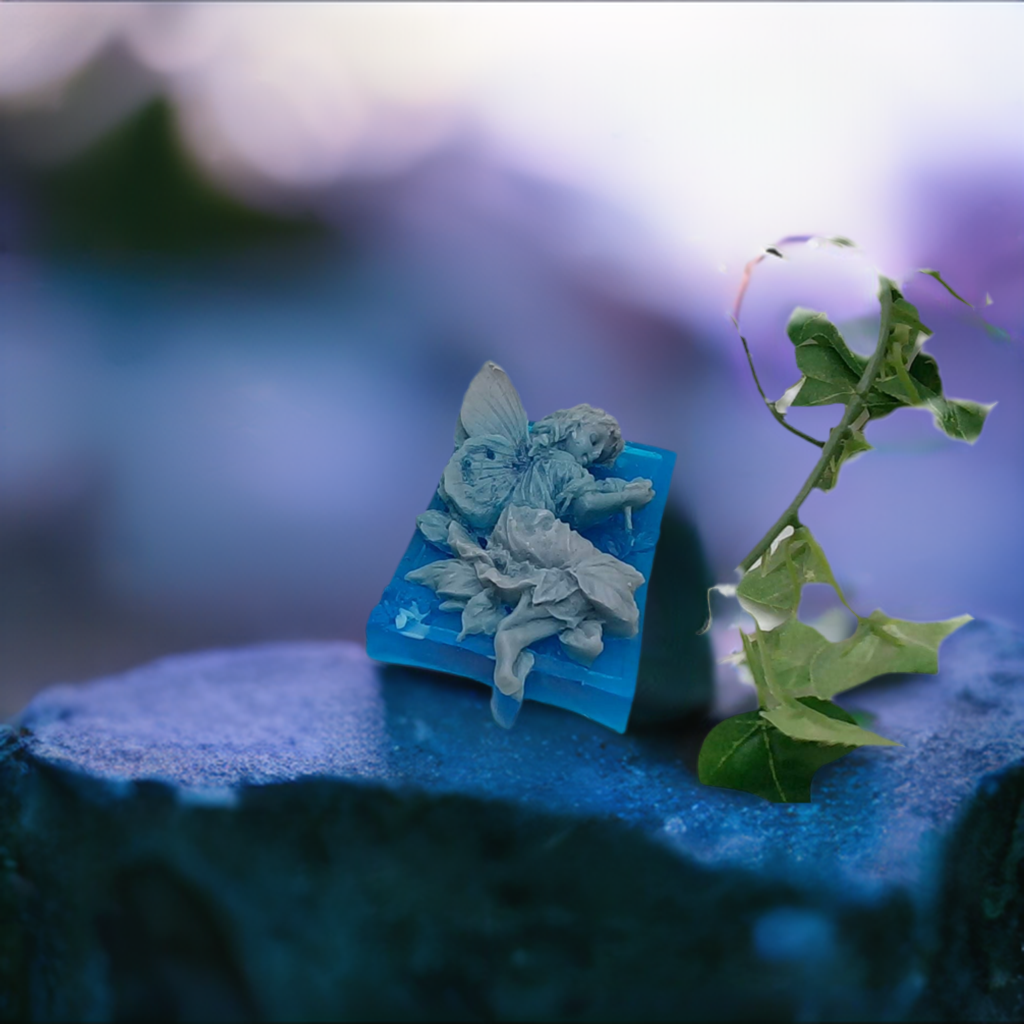 a piece of blue paper with a fairy figurine sitting on top of it